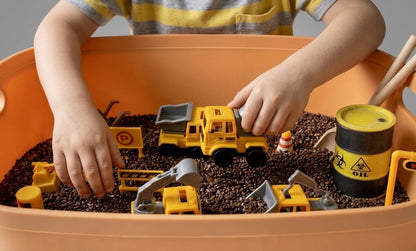 Child playing with the construction themed sensory bin